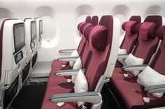 rows of empty seats in an airplane with red and white cushions on the back row