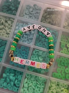 a plastic container filled with lots of green and white beads next to some type of magnets