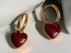 💖 Fall in love with these simple design wine red love heart dangle earrings! Their stunning heart shape in a rich wine red hue brings a romantic touch to any outfit, while the gold color circle adds a hint of elegance and charm. Perfect for adding a splash of color to your everyday style or making a statement on special occasions! ✨ These earrings gracefully sway with your movements, embodying a sense of playfulness and love. Whether you're out on a date or enjoying a night out with friends, th Elegant Red Double Heart Earrings, Elegant Red Heart Charm Earrings, Elegant Red Earrings With Heart Charm, Red Heart Earrings, Earrings Dangle Simple, Red Love Heart, Color Circle, Red Love, Heart Dangle Earrings