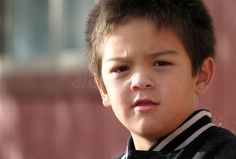 a close up of a young boy wearing a black and white striped jacket with his eyes closed