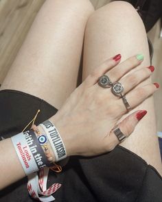 a woman's legs with bracelets and rings on her wrist, sitting down