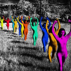 a group of people in colorful bodysuits are dancing