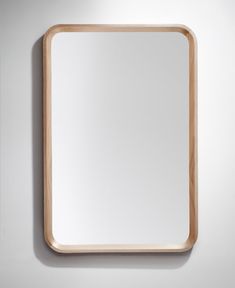 a square wooden mirror mounted on the wall above it's head, with a white background