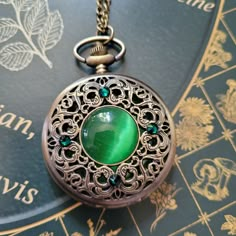 "This unique old fashioned styled pocket watch features a green cabochon at the center surrounded by emerald colored Swarovski crystals.  The clock face is revealed by pushing a button at the top.   There is also a mechanism, located at the top, that you can use to adjust the time.    A battery IS included in the watch so there is no need to purchase one separately.   The pocket watch measures  2-1/2\" tall and 2\" wide and it will come on a bronze chain in the length of your choice. Tip: If you Old Pocket Watch Aesthetic, Fancy Pocket Watch, Fantasy Pocket Watch, Fantasy Watch, Old Things Vintage, Pocket Clock, Steampunk Pocket Watch, Old Pocket Watches, Antique Pocket Watch