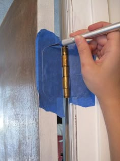 a person is cleaning the door with a blue cloth and a metal pole in front of them