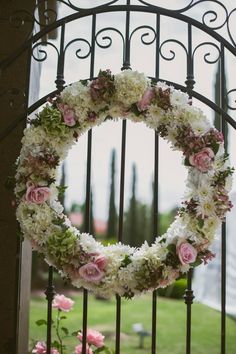 a floral wreath is hanging on a gate