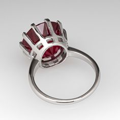 This bright Rubellite tourmaline cocktail ring is centered with one (1) round mixed cut natural Rubellite tourmaline weighing 9.80 carats that is set into a ten-prong setting. The ring measures 14.3mm at the top, rises 10.1mm above the finger, tapering to 1.6mm wide and 1.3mm thick at the base of the shank. It is currently a size 6.75. Modern Formal Ruby Ring, Modern Round Emerald Ring With Center Stone, Brilliant Cut Round Tourmaline Jewelry, Round Brilliant Cut Tourmaline Jewelry, Polished Tourmaline Round Ring, Round Tourmaline Solitaire Ring, Polished Tourmaline Rings, Ruby Tourmaline Ring With Center Stone, Formal Tourmaline Round Cut Rings