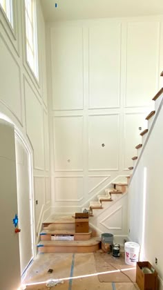 an empty room with white walls and wooden steps leading up to the second floor that is being remodeled