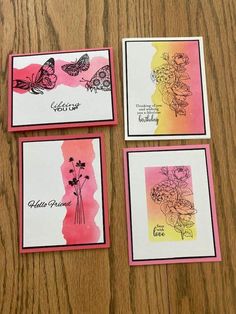 four cards with flowers and butterflies on them sitting on a wooden table next to each other