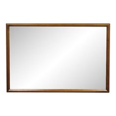 a wooden framed mirror on a white wall with a brown border around the frame and bottom edge