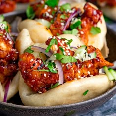 some tasty looking food in a bowl on a table with cucumbers and sauce