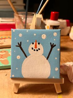 a painting of a snowman on an easel