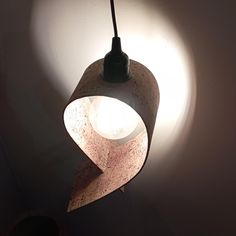 a light that is hanging from the ceiling in a room with a white wall behind it