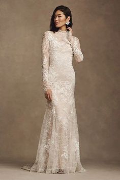 a woman in a long sleeved wedding dress