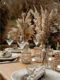 an image of a table setting with flowers in vases and plates on the table