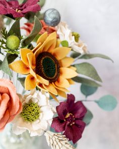 a vase filled with lots of different colored flowers