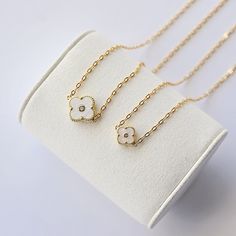 This delicate necklace showcases a dainty 14k gold chain, exuding subtle sophistication. At its center, a 14mm mother-of-pearl connector catches the light with a soft, radiant glow, adding a timeless touch. Designed with adjustable sizing for the perfect fit, this versatile piece can be worn alone or layered with others. Whether for everyday wear or a special occasion, it brings a sense of effortless elegance to any outfit. White Classic Necklace With Delicate Chain, Classic White Necklace With Delicate Chain, Formal White Cable Chain Necklace, Dainty White Necklace With Adjustable Chain, White Flower Pendant Necklace In Fine Jewelry Style, White Cable Chain Necklace For Formal Occasions, Minimalist White Tarnish Resistant Necklace, White Dainty Necklace With Adjustable Chain, 14k Gold White Round Pendant Necklace