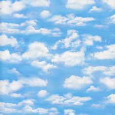 an airplane is flying through the blue sky with clouds in the background