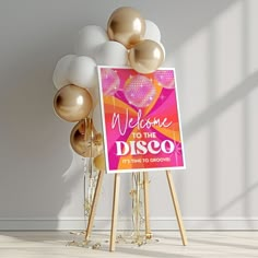 a welcome to the disco sign surrounded by gold and white balloons in an empty room