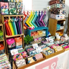 many different items are on display for sale at the market stall, including colorful fabrics and fabric