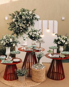 three round tables topped with cakes and cupcakes on top of each other in front of a wall