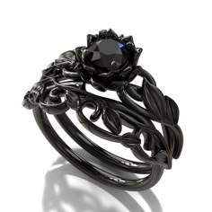 "If you're looking for an engagement ring like no other, stop right here. This AMAZING piece of fine jewelry is the perfect expression of your eternal love. Its BLACK colors bring out the beauty of this ring. This engagement ring is created of gleaming, 14kt black gold, carved into an elaborate leaf design at the top. A striking black diamond sits boldly at the center, surrounded by black gold petals, forming the eye-catching image of a lotus flower. ★See A Video Of This Amazing Ring Here★ https Lotus Flower Engagement Ring, Simpul Dasi, Black Gold Engagement Rings, خواتم خطوبة, Gothic Engagement Ring, Black Diamond Engagement Ring, Flower Engagement, Black Engagement Ring, Cute Engagement Rings