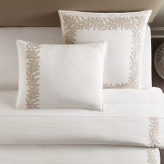 a bed with white sheets and pillows on top of it