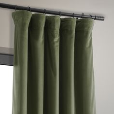 the green curtains are hanging in front of the window