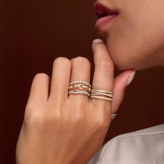 a close up of a person wearing two rings on their fingers and one ring in the other hand