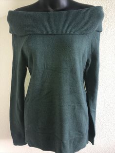 an off the shoulder green sweater on a mannequin