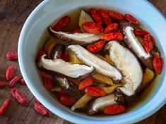 a bowl filled with sliced bananas, tomatoes and other vegetables on top of a wooden table