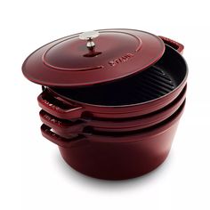 the red casserole is stacked on top of each other and has an open lid