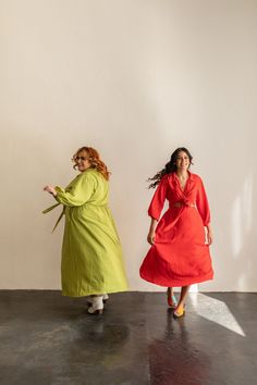 two women in bright colored dresses are dancing