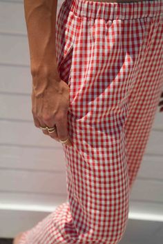 Score trendy Gingham Pants made of cotton canvas in a red check pattern. Designed with a comfy fit and a low waist, these bottoms will elevate your look when worn with a top and stylish boots or heels. pants 50% cotton 50% polyester lininig 100% rayon gingham print inner drawstring tie elastic waistband double pocket at back non stretch fully lined MODEL DETAILS: Height 6’1 Bust 34DD Waist 28 wearing size small Casual Plaid Pants For Picnic, Gingham Cotton Pants, Gingham Bottoms With Pockets For Picnic, Summer Gingham Pants For Picnic, Summer Cotton Pants For Picnic, Summer Picnic Cotton Pants, Red Bottoms For Summer Picnic, Red Summer Bottoms For Picnic, Plaid Cotton Bottoms For Picnic