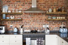 a kitchen with brick walls and white cabinets