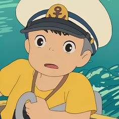 a young boy wearing a sailor's hat and holding a steering wheel in front of an ocean background