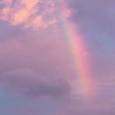 a rainbow in the sky with clouds above