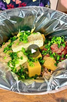 a plastic bag filled with food on top of a wooden table