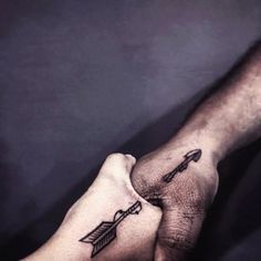 two hands holding each other with arrows on their wrist tattoo designs for men and women