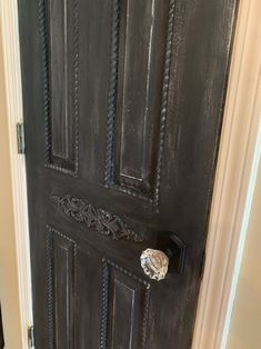 the door is painted black and has an ornate handle on it's front door