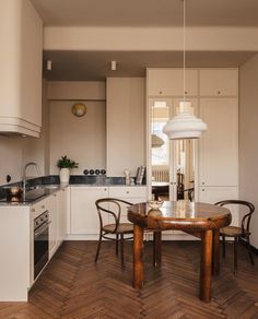 a wooden table sitting in the middle of a kitchen next to a stove top oven