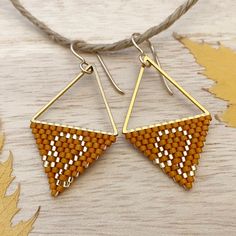 "Leo: July 23 to August 22.  Power color: Orange and/or Gold 0.875\" wide and 1.875 long.  Built on a stainless steel triangle for a geometric (tarnish free) airy and dainty flair. Heavy gauge gold filled ear wires are sturdy and hypoallergenic. A perfect accessory for the generous and brave fire sign!" Handmade Geometric Yellow Jewelry, Geometric Beaded Gold Earrings, Gold Beaded Geometric Earrings, Geometric Gold Beaded Earrings, Gold Geometric Beaded Earrings, Geometric Beaded Gold Jewelry, Gold Beaded Geometric Jewelry, Geometric Gold Beaded Jewelry, Gold Geometric Beaded Jewelry