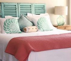 a bed with blue shutters on the headboard and pillows in front of it