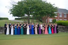 a group of people standing on top of a lush green field next to a building