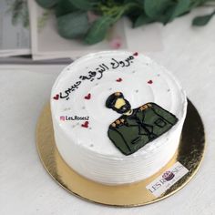 a white cake decorated with an image of a soldier's uniform and hearts on it