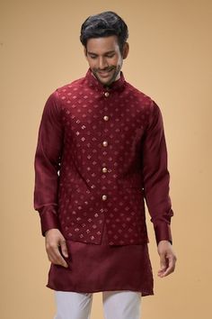 Maroon sleeveless bundi crafted in dupion silk featuring sequin-thread bloom quad embroidery. Paired with a solid maroon kurta and white pant., Fit: Relaxed Elegant Chanderi Nehru Jacket For Diwali, Festive Bollywood Cotton Silk Nehru Jacket, Elegant Chanderi Nehru Jacket With Pallu, Elegant Chanderi Nehru Jacket For Festive Occasions, Sleeveless Nehru Jacket With Zari Work For Transitional Season, Cotton Silk Nehru Jacket For Wedding And Festivals, Designer Chanderi Nehru Jacket Fitted, Festive Cotton Silk Nehru Jacket With Pallu, Fitted Chanderi Nehru Jacket For Designer Wear