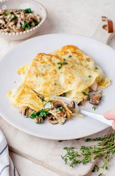 an omelet on a plate with mushrooms and parsley in the background text overlay reads mushroom crepes