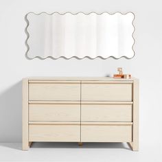 a white dresser with a mirror above it