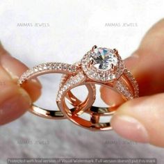 someone is holding two wedding rings in their hand, with the ring setting on top of each other