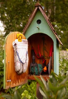 a bird house with gardening tools in it